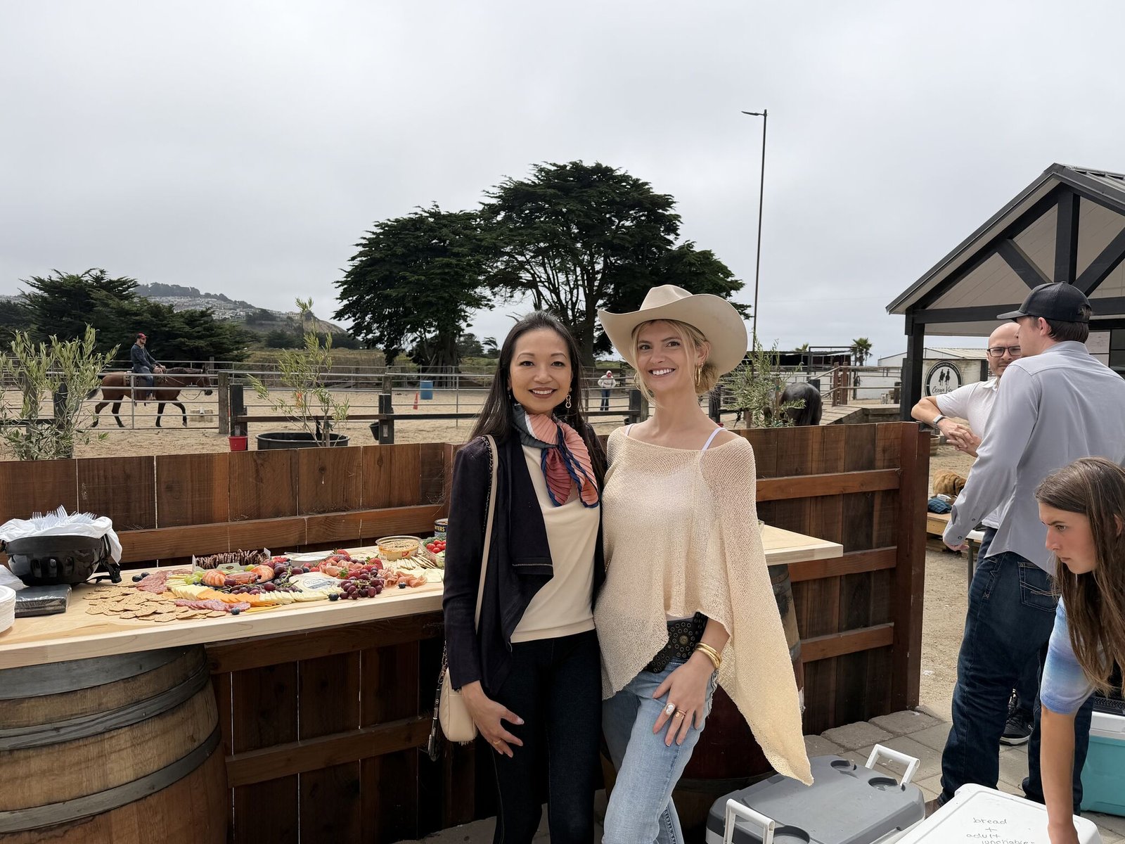Guests at the ranch bar with the arena and coastal cypress behind them