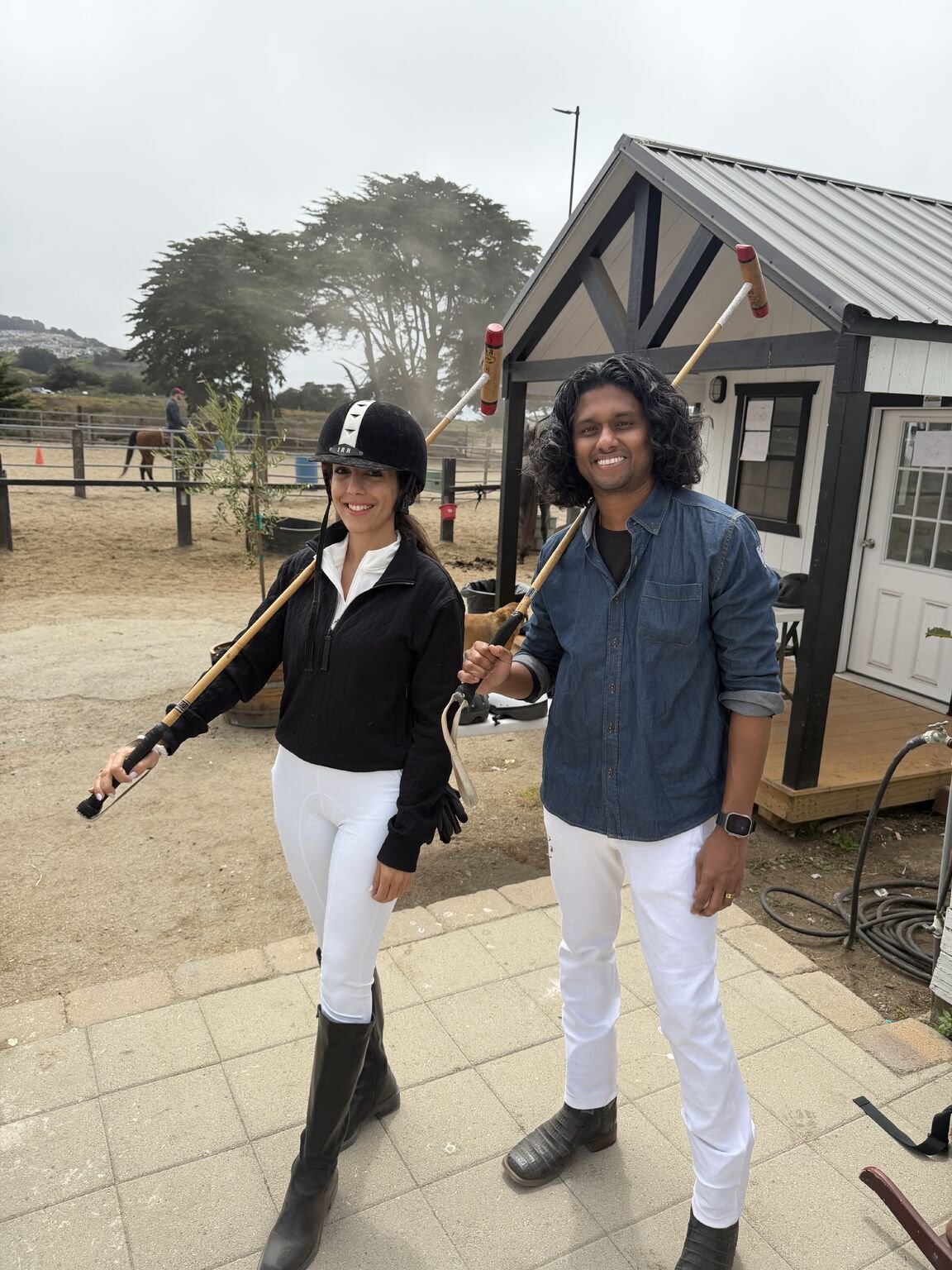 Two guests with polo mallets before an arena session at Ocean View Stables