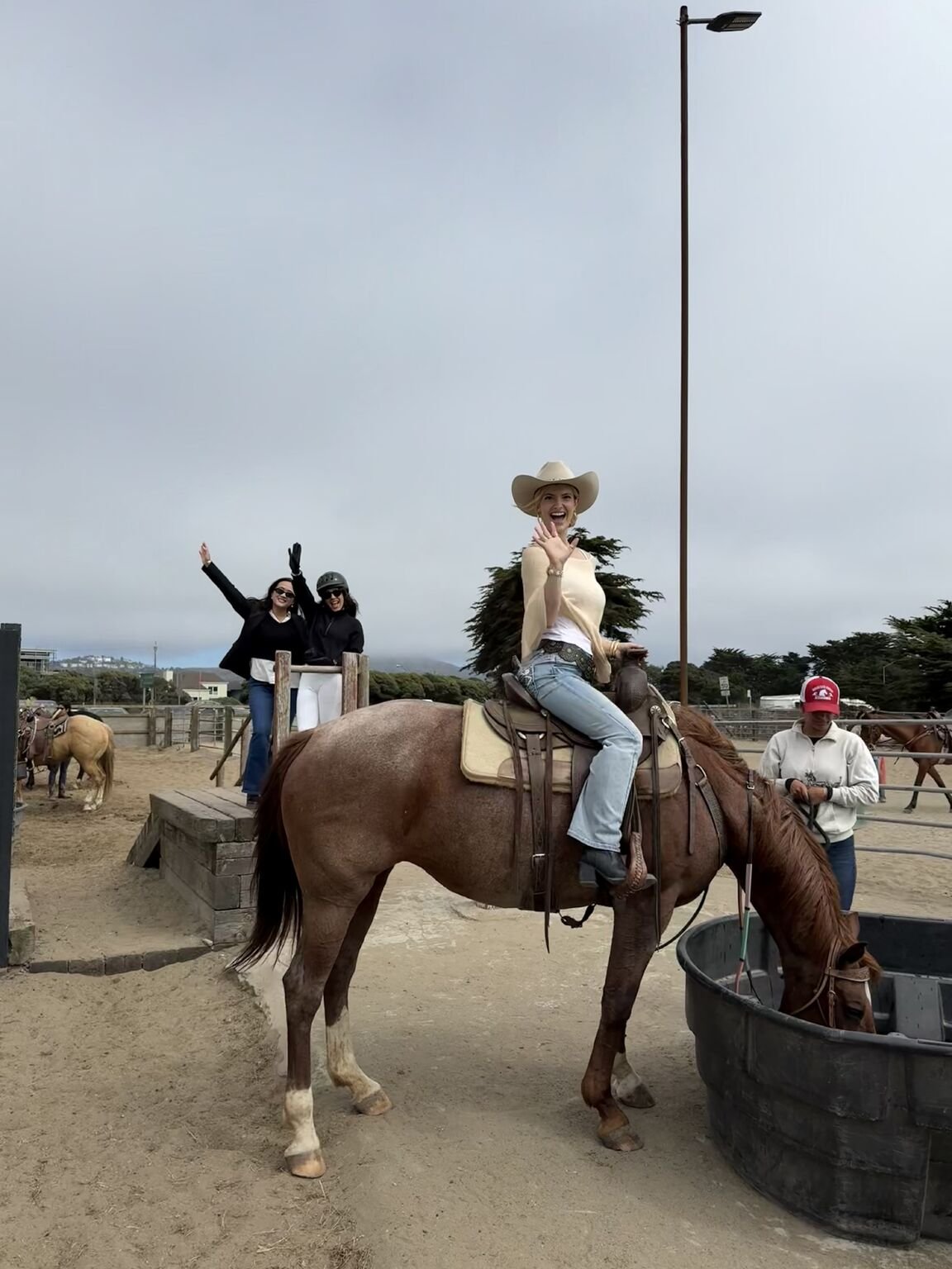 A guest riding at Ocean View Stables while the rest of the team cheers from the rail