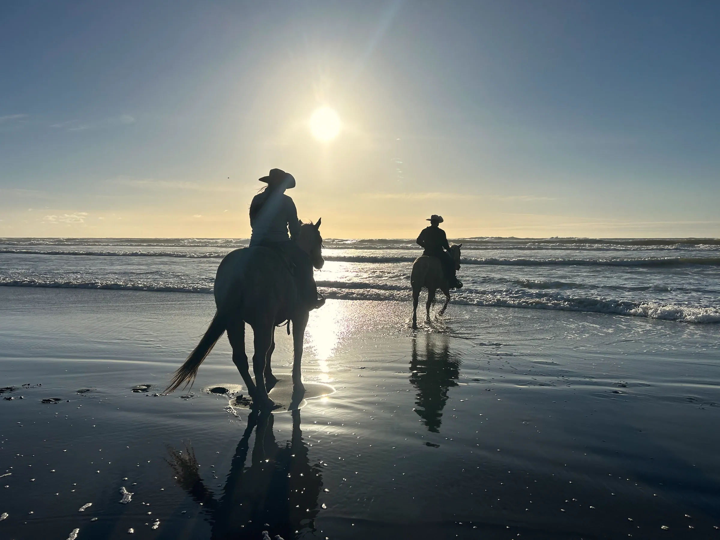 Two riders on horseback at the edge of the Pacific below the Daly City bluffs