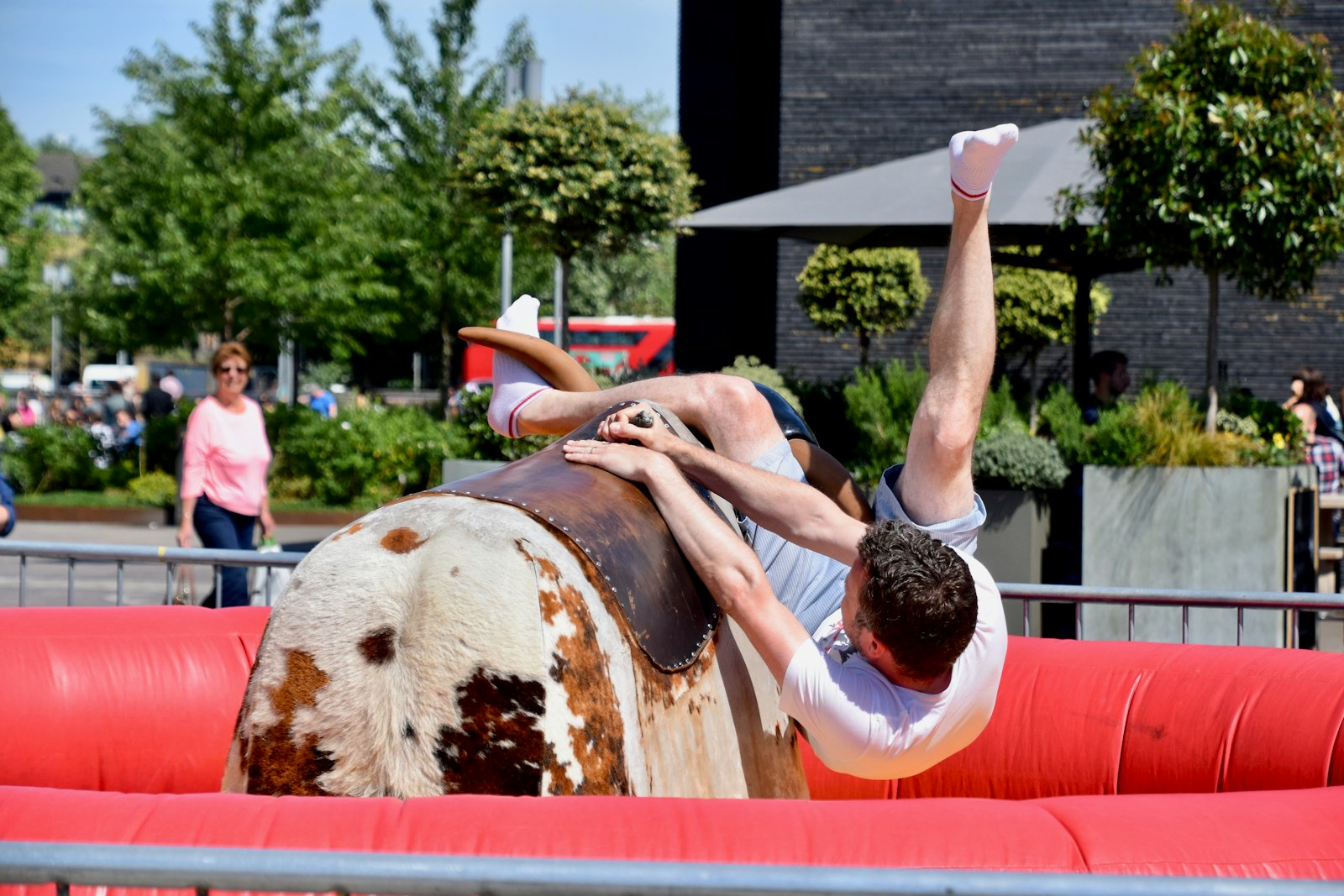 A rider on a mechanical bull inside an inflatable safety arena