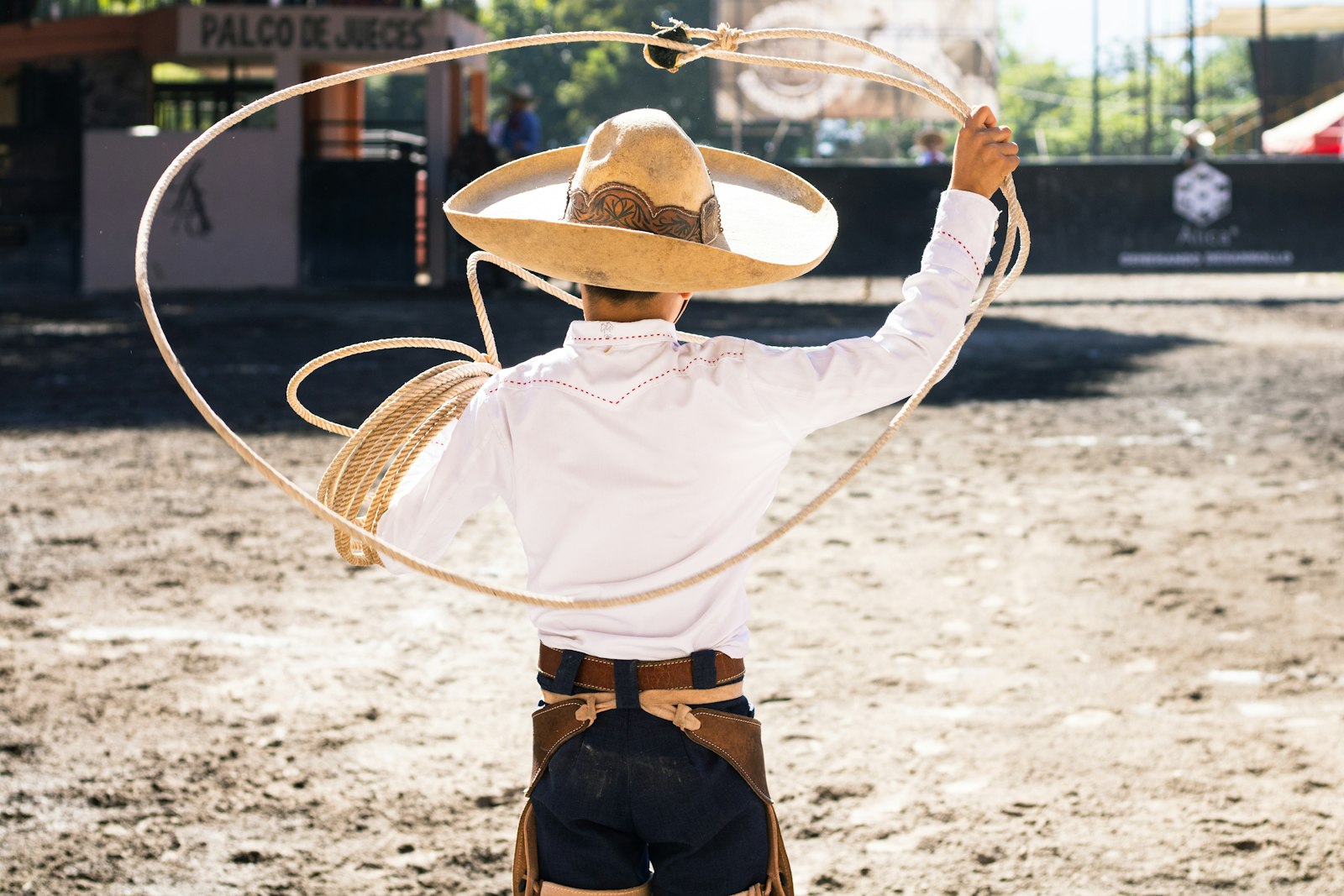 A roper swinging a lasso in an arena